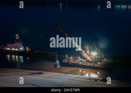 Livraison de sable sur les plages de Samara Une grue à flèche à portique plein-tour décharge le sable d'une barge sur le rivage région de Samara Samara Russie Copyright : xs Banque D'Images