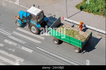 vieux tracteur avec une remorque pour le nettoyage des ordures de rue, vue de dessus Banque D'Images