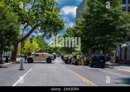 Washington, DC, États-Unis — 10 juillet 2024. Deux véhicules militaires forment un barrage routier lors d'un sommet de l'OTAN parrainé par les États-Unis ; le personnel militaire américain se réunit à proximité. Banque D'Images