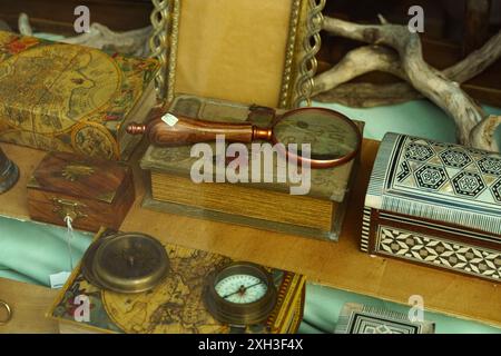 Astorga, Espagne - 3 juin 2023 : une table couverte de nombreux livres avec une loupe placée sur le dessus. Banque D'Images