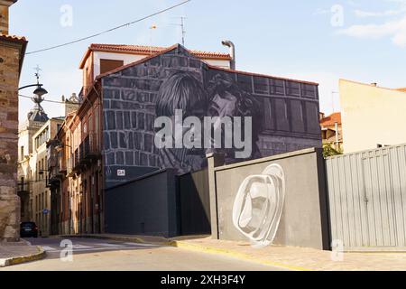 Une murale en noir et blanc représentant un homme et un enfant regardant le spectateur, située dans une rue étroite d'Astorga, en Espagne. Banque D'Images