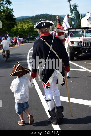 Un homme et son fils, vêtus d'une réplique du XVIIIe siècle de tenue militaire de la guerre d'indépendance, participent à un défilé du 4 juillet à Hendersonville, Caroline du Nord. Banque D'Images