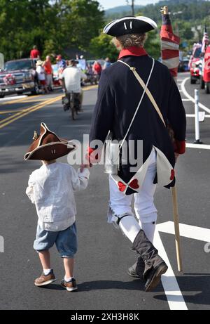 Un homme et son fils, vêtus d'une réplique du XVIIIe siècle de tenue militaire de la guerre d'indépendance, participent à un défilé du 4 juillet à Hendersonville, Caroline du Nord. Banque D'Images