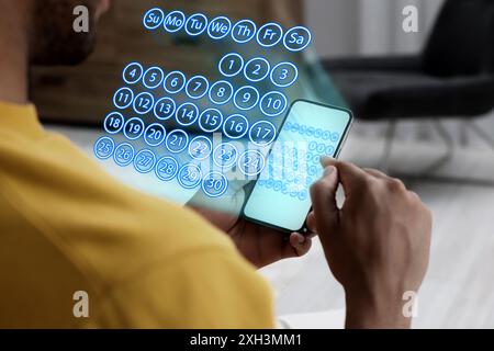 Établissement d'un calendrier. Homme utilisant un smartphone, gros plan. Calendrier virtuel projeté à partir de l'appareil Banque D'Images