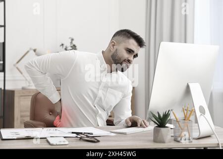 Homme souffrant de mal de dos dû à une mauvaise posture au travail Banque D'Images