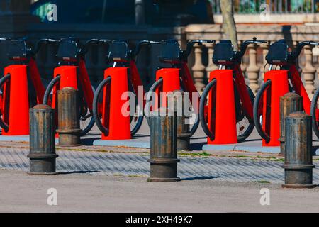 Rangée de porte-vélos rouges sont alignés sur le trottoir à louer. Bicyclettes debout en ligne droite Banque D'Images