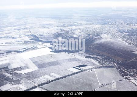 Scène hivernale avec de la neige couvrant le sol et des arbres givrés. Le ciel est nuageux et le sol est couvert de neige. Vue aérienne de la campagne hivernale Banque D'Images