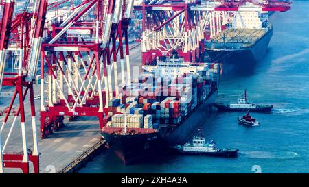 QINGDAO, CHINE - 11 JUILLET 2024 - des conteneurs sont chargés et déchargés au terminal à conteneurs de Qianwan du port de Qingdao, port de Shandong, Chine, 11 juillet Banque D'Images