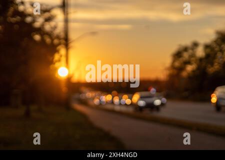 Coucher de soleil doré sur une route urbaine - premier plan flou avec effet bokeh - teintes chaudes du soir - atmosphère tranquille de fin de journée. Prise à Toronto, Canada Banque D'Images