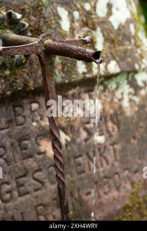 Gros plan de l'eau potable s'écoulant d'un vieux robinet de fontaine rouillé (Spitzbrunnen), Kaiserslautern, Allemagne Banque D'Images