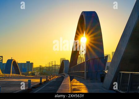 Coucher de soleil enchanteur vu à travers l'arc du 6th Street Bridge à Los Angeles, créant un effet de soleil captivant qui accentue l'Ar unique Banque D'Images