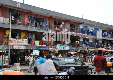 Scène animée avec marché couvert et route occupée en face du marché. Banque D'Images