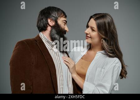 Un homme barbu et une femme en tenue élégante se regardent amoureusement. Banque D'Images