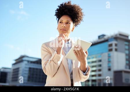 Confiante jeune femme d'affaires tenant une tablette dans un cadre urbain Banque D'Images