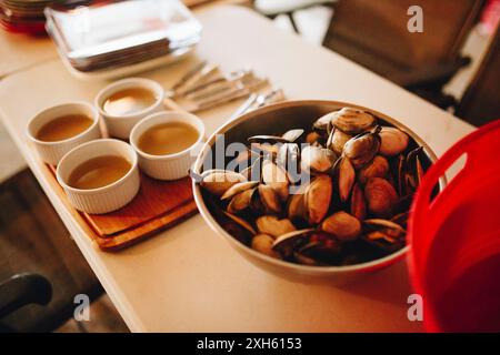 Bowl of clams with dipping sauces on a table. Banque D'Images