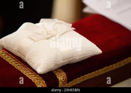 Deux anneaux de mariage sont posés sur un oreiller de dentelle blanche lors d'une cérémonie de mariage Banque D'Images