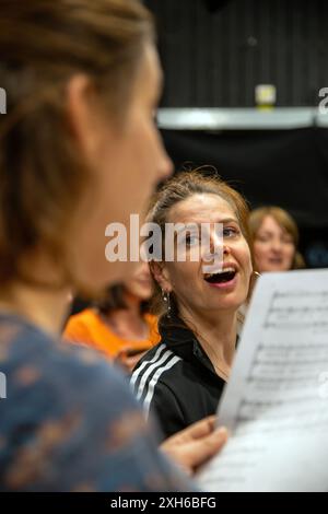 02 juillet 2024, Bavière, Nuremberg : la directrice de chœur Ana Labus donne le ton tandis qu'une chanteuse tient une feuille de musique à la main. Le chœur de femmes Desirenen célèbre un grand succès avec un répertoire moderne qui va au-delà de la littérature chorale habituelle et attire de plus en plus de chanteuses. En conséquence, deux autres chorales ont déjà émergé de ceux qui s'intéressent au projet de chœur fondé en 2013. Photo : Pia Bayer/dpa Banque D'Images