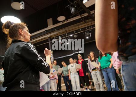 02 juillet 2024, Bavière, Nuremberg : la directrice de chorale Ana Labus donne des instructions pour la chanson suivante, tandis que les chanteurs avec une partition dans leurs mains attendent leur signal. Le chœur de femmes de Nuremberg célèbre un grand succès avec un répertoire moderne qui va au-delà de la littérature chorale habituelle et attire de plus en plus de chanteuses. En conséquence, deux autres chorales ont déjà émergé de ceux qui s'intéressent au projet de chœur fondé en 2013. Photo : Pia Bayer/dpa Banque D'Images