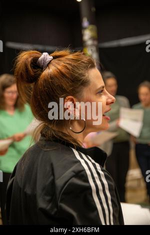 02 juillet 2024, Bavière, Nuremberg : la directrice de chorale Ana Labus donne des instructions pour la chanson suivante, tandis que les chanteurs avec une partition dans leurs mains attendent leur signal. Le chœur de femmes de Nuremberg célèbre un grand succès avec un répertoire moderne qui va au-delà de la littérature chorale habituelle et attire de plus en plus de chanteuses. En conséquence, deux autres chorales ont déjà émergé de ceux qui s'intéressent au projet de chœur fondé en 2013. Photo : Pia Bayer/dpa Banque D'Images