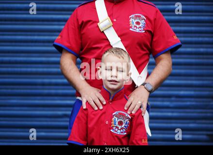 ***PERMISSION PARENTALE ACCORDÉE*** Jamie Reston, de Glasgow, avec son fils Ashton James Reston (5 ans) alors que les gens se rassemblent au Carlisle Circus de Belfast avant un défilé de l'ordre Orange dans le cadre des célébrations du 'douzième de juillet'. Date de la photo : vendredi 12 juillet 2024. Banque D'Images