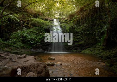 Vue sur l'une des spectaculaires cascades de Lamiña, sur la rivière Barcenillas, en Cantabrie, Espagne, avec une longue exposition et une atmosphère mystérieuse Banque D'Images