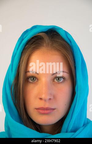 Portrait d'une jeune femme blonde portant un châle turquoise. Banque D'Images