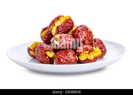 Pile de jujujube chinois dénoyauté séchée farcie de noyer croquant dans une plaque de céramique blanche isolée sur fond blanc avec chemin de découpage. Banque D'Images