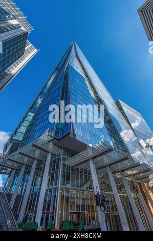 Vue en bas angle du gratte-ciel en verre moderne construisant le Shard avec le ciel bleu et les nuages reflétés dans ses fenêtres. Londres. Royaume-Uni. Banque D'Images