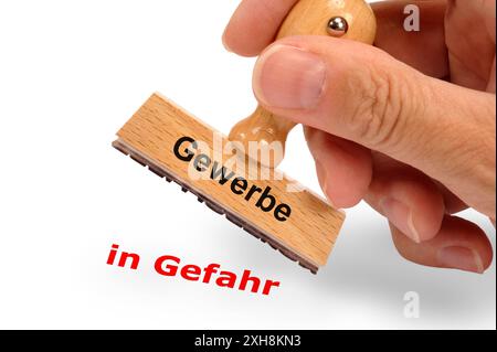 Gewerbebetrieb Ein Holzstempel ist beschriftet mit dem Aufdruck Gewerbe und dem Abdruck in Gefahr *** entreprise commerciale Un timbre en bois est étiqueté Banque D'Images