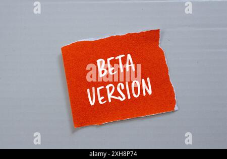 Message de la version bêta écrit sur un morceau de papier orange déchiré déchiré avec fond gris. Symbole de version bêta conceptuelle. Copier l'espace. Banque D'Images