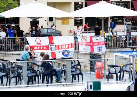 Les fans d'Angleterre sur Friedrichstrasse drapent des drapeaux près de la rivière Spree à Berlin, en Allemagne. L'Angleterre affrontera l'Espagne dans la finale de l'UEFA Euro 2024 dimanche. Date de la photo : vendredi 12 juillet 2024. Banque D'Images