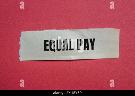 Message d'égalité salariale écrit sur du papier déchiré avec fond rouge. Symbole conceptuel de l'égalité salariale. Copier l'espace. Banque D'Images