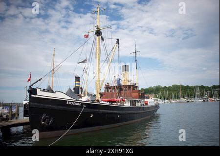 Flensburg, Schleswig-Holstein Dampfrundum 2024 Flensburg, Die BUSSARD, ein Tonnenleger, wurde 1906 von der Meyer-Werft in Papenburg gebaut. Mit einer Dreifach-Expansionsdampfmaschine von 540 PS leistete das Schiff 74 Jahre lang als Tonnenleger und Eisbrecher Dienst, bis es am 31. Décembre 1980 außer Dienst gestellt wurde. 1981 wurde die BUSSARD an das Kieler Schifffahrtsmuseum übergeben und lag dort 20 Jahre als Museumsschiff. AB 2001 begann die Restaurierung zur Fahrfähigkeit, die 2006 mit der Genehmigung als Traditionsschiff und 2007 mit der Anerkennung als schwimmdes Denkmal abgeschlossen Banque D'Images