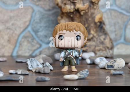 Funko Pop figurine d'action vinyle de Sam hobbit du film fantastique le Seigneur des anneaux. Jouet de collection tenant l'épée debout près du vieil arbre et des pierres. Banque D'Images