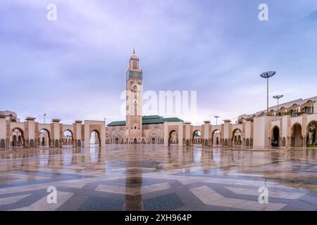 Vue imprenable sur la mosquée Hassan II après la pluie, avec ses imposants minarets et ses cours réfléchissantes. Photographié à Casablanca, Maroc. Banque D'Images