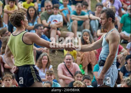 Viladecasn, ESPAGNE - 12 JUILLET 2024 : deux athlètes se serrent la main lors d'un événement sportif bondé, symbolisant l'esprit sportif et la camaraderie au milieu de la compétition. Banque D'Images