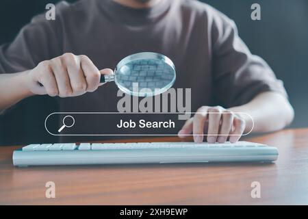 Recherche d'emploi, trouver du travail, entretien d'embauche, données technologie de recherche optimisation des moteurs de recherche, chômage, recrutement, homme à l'aide d'une loupe an Banque D'Images