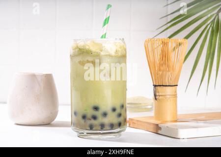 Thé à bulles vert matcha boba avec perle de tapioca. Boisson glacée froide asiatique tendance avec boules de tapioca foncées et crème fouettée non laitière, espace copie Banque D'Images