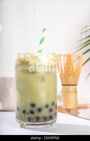 Thé à bulles vert matcha boba avec perle de tapioca. Boisson glacée froide asiatique tendance avec boules de tapioca foncées et crème fouettée non laitière, espace copie Banque D'Images