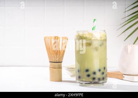 Thé à bulles vert matcha boba avec perle de tapioca. Boisson glacée froide asiatique tendance avec boules de tapioca foncées et crème fouettée non laitière, espace copie Banque D'Images