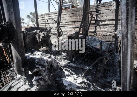 Naplouse, Palestine. 12 juillet 2024. Vue générale d'un bulldozer brûlé par des colons juifs de la colonie israélienne de Homesh. Un groupe de colons masqués a attaqué des magasins et des maisons dans le village de Bazaria, au nord de la ville de Naplouse, en Cisjordanie. Crédit : SOPA images Limited/Alamy Live News Banque D'Images