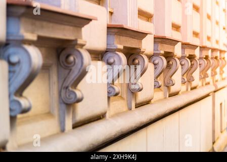 Une rangée de supports décoratifs complexes sur une façade de bâtiment, mettant en valeur l'artisanat orné et les détails architecturaux. Les tons chauds et l'éclairage doux créent un sentiment d'élégance classique Banque D'Images