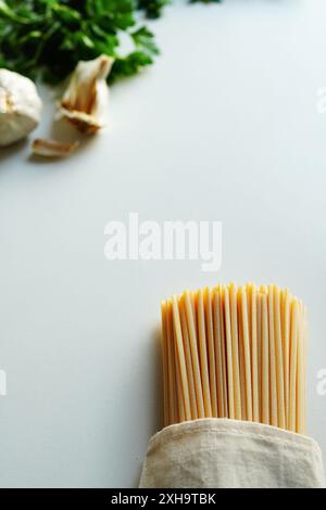Persil italien et spaghetti sur fond blanc Banque D'Images