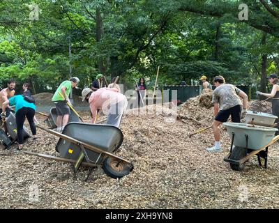 Des bénévoles redistribuent le paillis à Prospect Park à Brooklyn, NY. Le paillis aide les arbres à pousser, réduit les mauvaises herbes, préserve l'humidité du sol et minimise l'érosion du sol. Banque D'Images