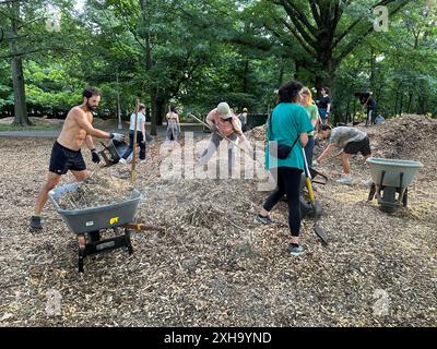 Des bénévoles redistribuent le paillis à Prospect Park à Brooklyn, NY. Le paillis aide les arbres à pousser, réduit les mauvaises herbes, préserve l'humidité du sol et minimise l'érosion du sol. Banque D'Images