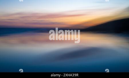 Mouvement intentionnel de la caméra, ICM, coucher de soleil, falaises, réflexion de la mer et de la plage Banque D'Images