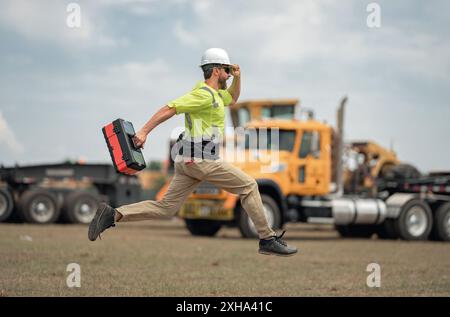 Construction rapide. Drôle de travailleur de la construction sauter. Saut enthousiaste des constructeurs dans le casque. Travailleur dans un casque de sécurité. Ingénieur de construction en saut uniforme de constructeur Banque D'Images