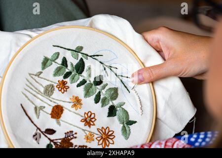 Mains de femme travaillant sur la broderie avec fil et aiguille Banque D'Images