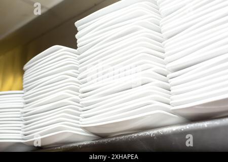 Une vue de piles d'assiettes sur une étagère, dans un cadre de cuisine de restaurant. Banque D'Images