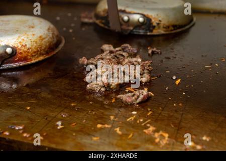 Une vue de la cuisson du bœuf haché sur une plaque chauffante, dans un cadre de cuisine de restaurant. Banque D'Images